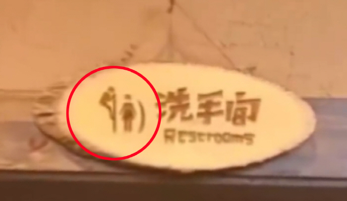 Controversy over a toilet sign where a man peeks at a woman in the next compartment...Is this funny?