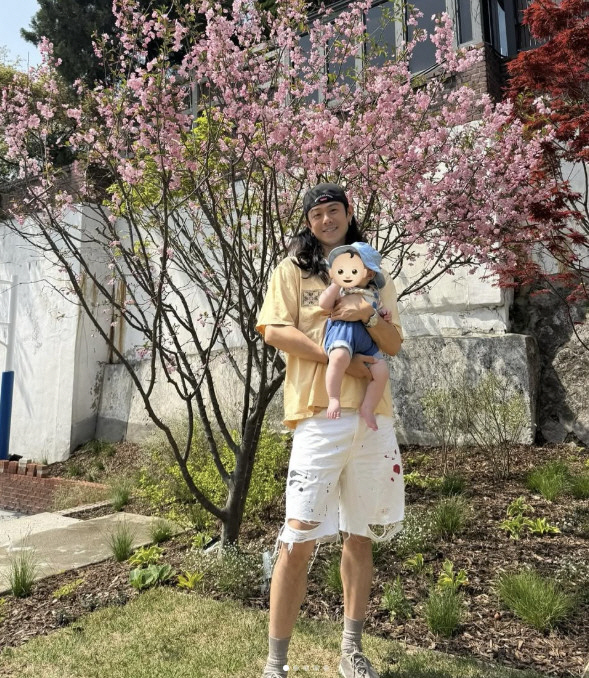 Beenzino, looking at flowers while holding his son who grew up...The happiest long-haired dad in the world