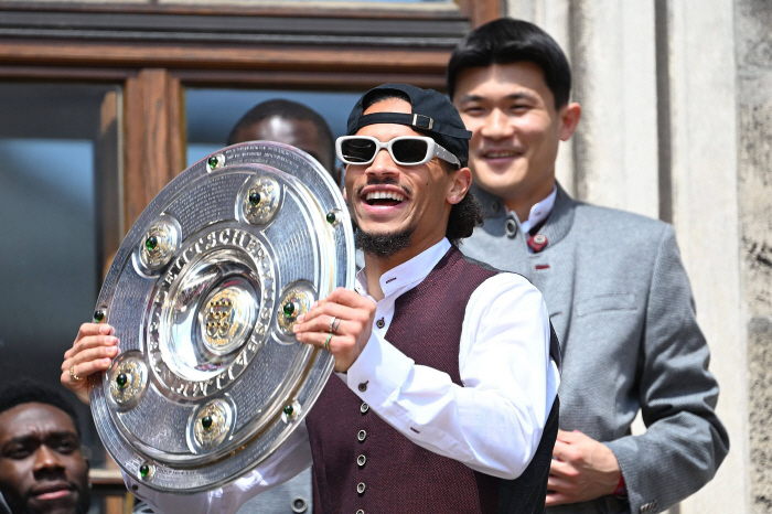 Happy Minjae, wearing traditional German clothes, flashing trophies in front of crowds...Attending the Munich Victory Event