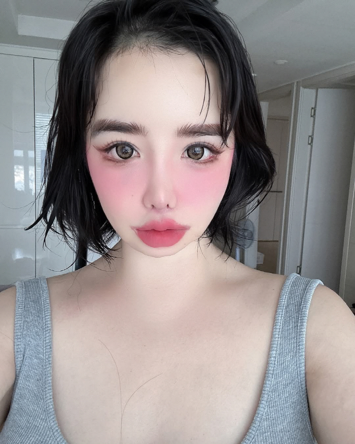 Park Bom's face is covered with pink blusher and bold pink ♥ love makeup