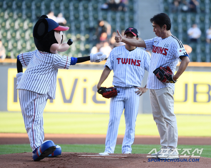  Ryu Seung-ryong throws the first pitch while being cheered on by Mickey Mouse