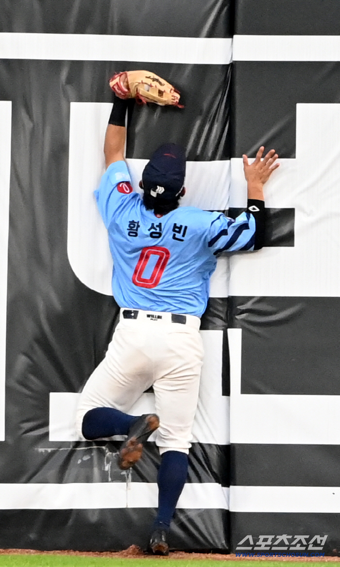  Hwang Sung-bin collides with the fence after catching the ball