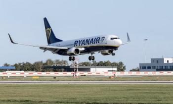 Woman trying to open emergency exit door for flying aircraft stops passengers