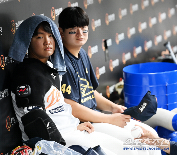  Jung Woojoo and Kim Seohyun, sitting side by side in the dugout