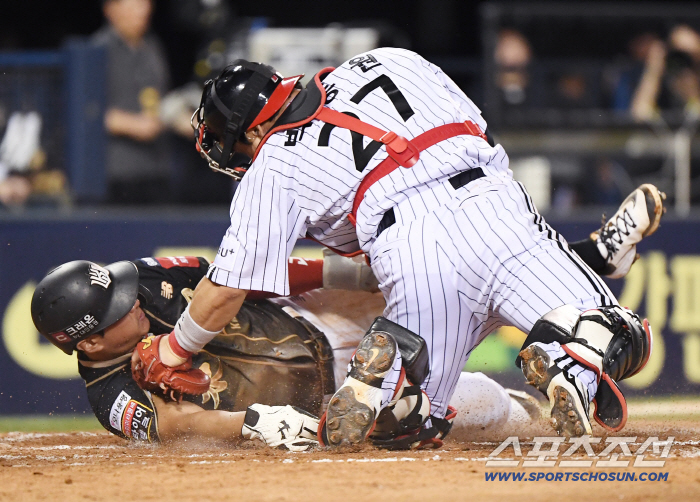  Hwang Jae-gyun folds his left arm and touches the home base with his right arm