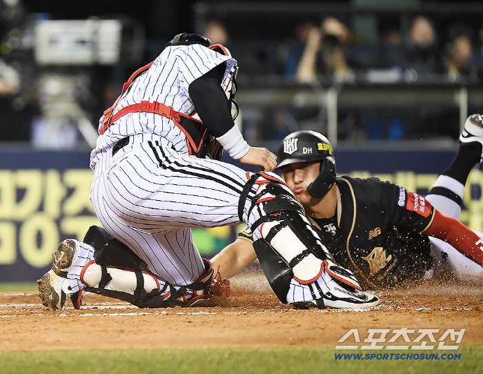  Hwang Jae-gyun folds his left arm and touches the home base with his right arm