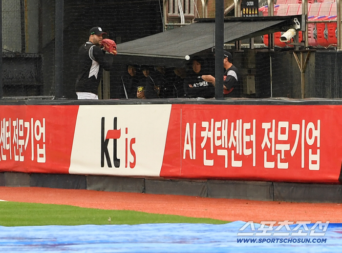  Heysus pitching a bullpen in the rain