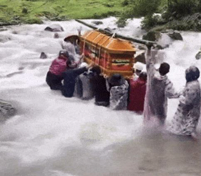 Funeral across a torrent with a coffin in a heavy rain...The sky cried, and the bereaved family cried